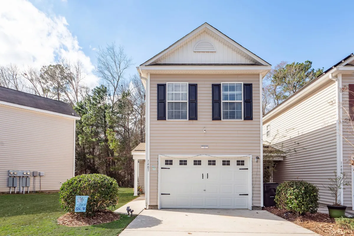 The townhouse’s exterior view highlights the front door, garage, and windows set amidst manicured landscaping. The scene suggests a friendly neighborhood atmosphere, with space for outdoor family activities and a welcoming entry that signals both tranquility and connection to the surrounding community.