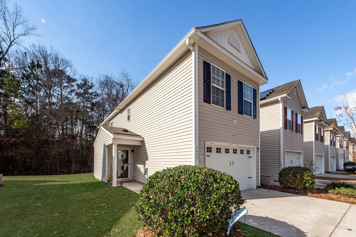 This image captures the inviting exterior of the home, showcasing the well-maintained front yard, landscaping, and welcoming facade. The setting is bright and cheerful, suggesting a peaceful yet vibrant place to return to after exploring the city.