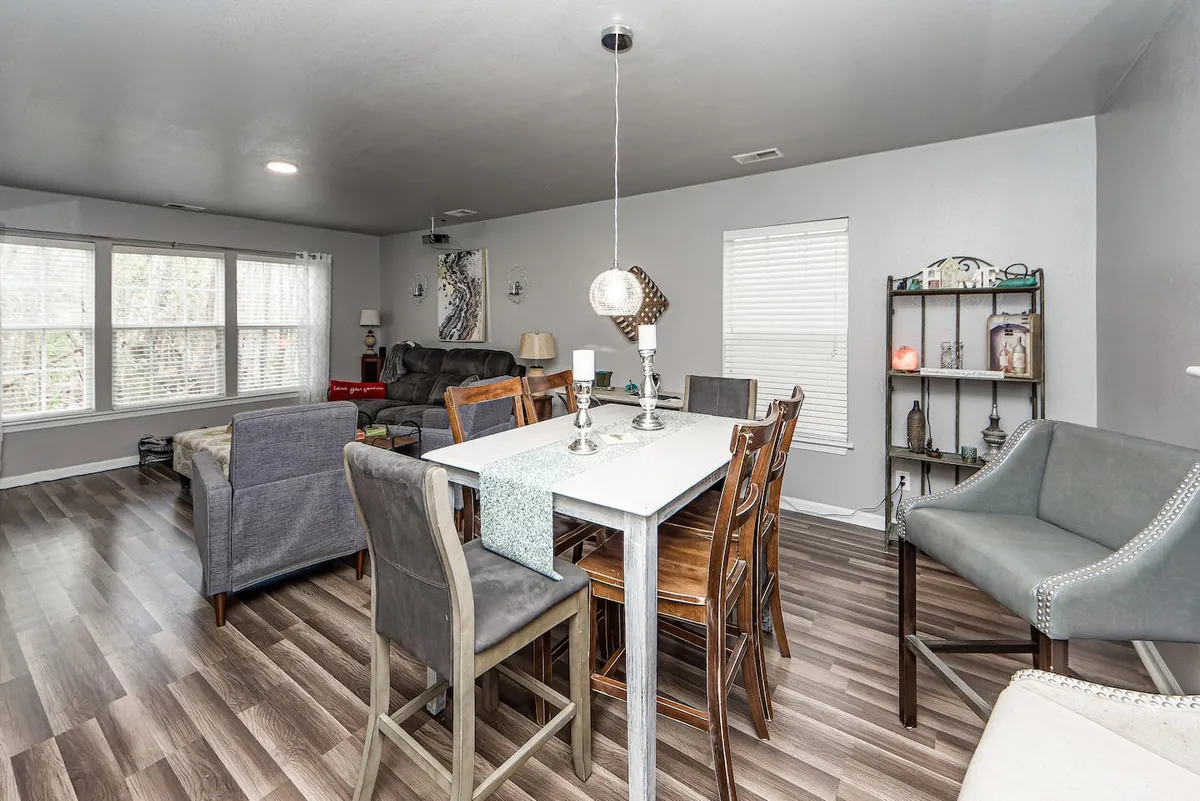 The dining space is shown with a tastefully set dining table, comfortable seating, and large windows letting in natural light, fostering a cozy and welcoming atmosphere for family dinners and celebrations.